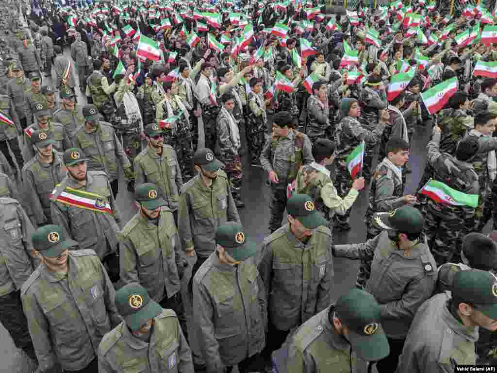 School students wave national flags as Islamic Revolutionary Guards Corps members arrive in Azadi (Freedom) Square.