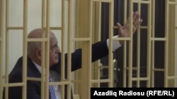 Former Azerbaijani Health Minister Ali Insanov sits in a cage during his trial in Baku on charges of drugs possession and assault. 