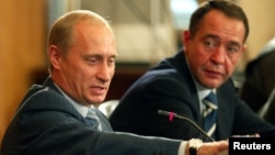 Russian President Vladimir Putin (left) gestures as Media Minister Mikhail Lesin listens to him during a meeting with local press in the far eastern city of Vladivostok in August 2002.