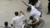 Men in civilian clothes beat a protester during a demonstration on June 14. 