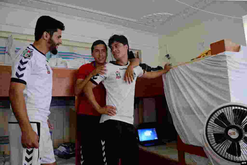 Afghan football player Emal Mangal (left), 19, talks with other players in his dorm room in Kabul on September 2.