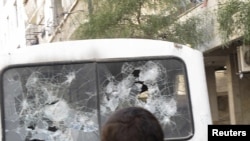 Syrians gather around a bus with shattered windows after shootings during a protest near Damascus. The UN estimates that at least 2,700 people have died in during the unrest in the country. 