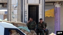 Soldiers man a checkpoint in the city of Rastan in central Homs Province.