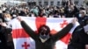 A Georgian opposition supporter holds a national flag during a rally following the arrest of the leader of the opposition ENM party in Tbilisi on February 23. 