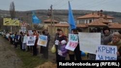 Крымчанки с крымскотатарскими флагами и плакатами за мир стоят у одной из крымских автотрасс. Крым, 08 марта 2014 г.