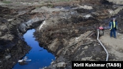 A worker takes part in a clean-up operation following a massive fuel spill in the Ambarnaya River outside Norilsk on June 15. The area has been hit by a number of environmental catastrophes in the past month. 