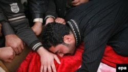 An Iraqi man weeps over the body of a relative killed in a bomb attack in Ramadi on December 30.