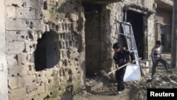 Boys remove debris from houses that residents say were damaged during a military crackdown on antigovernment protesters in Talbiseh, Syria.