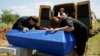 Relatives cry over the coffins of three children killed by a grenade explosion in the Yenakiyeve area near Donetsk earlier this month.