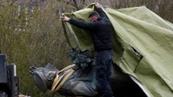 Рабочий накрывает памятник советскому полководцу Второй мировой войны, маршалу Ивану Коневу после его демонтажа с постамента в Праге, 3 апреля 2020 года