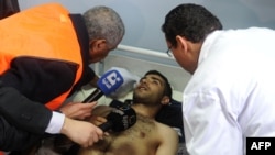 An Arab League observer speaks with a wounded man in a hospital after a powerful explosion in Damascus earlier this month.