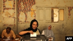 An Egyptian Christian Coptic woman casts her vote in the country's presidential election at a polling station in Cairo. 