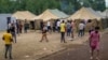 Migrants walk inside a camp that has been built to house them at a military training ground, some 38 kilometers from the Lithuanian capital, Vilnius. 