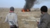 Sunni Muslim fighters watch as a police vehicle burns during clashes in the Iraqi city of Ramadi on January 2. Militants have seized control of large parts of Ramadi and Fallujah amid sectarian violence in recent days. 