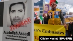 Iranian opposition activists protest with poster depicting Iranian official Asadollah Assadi in Brussels in 2018.