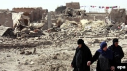 Women in Mosul walk through the site of a bombing in September. Security has not improved in recent months.