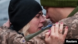 A Ukrainian soldier says goodbye to his wife after a short break from his frontline duties at the train station in Kramatorsk on February 14.