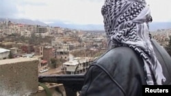 A member of the Free Syrian Army with an assault rifle stands guard during a patrol in the western Syrian border town of Zabadani on January 16.