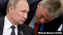 Russian President Vladimir Putin's spokesman, Dmitry Peskov (right), has been busy this week issuing nondenials on his boss's behalf. (file photo) 