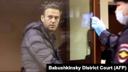 Russian opposition leader Aleksei Navalny, charged with defaming a World War II veteran, looks out from inside a glass cell during a court hearing in Moscow on February 5.