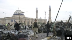 Iraqi soldiers inspect the site of one of the car-bomb attacks, in the Al-Qahira neighborhood of Baghdad, on December 8.