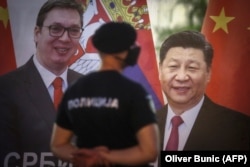 A policeman stands guard by a banner depicting Serbian President Aleksandar Vucic and Chinese leader Xi Jinping in front of the National assembly building in Belgrade in 2020.