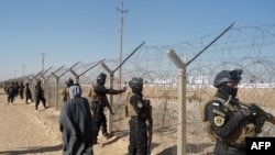 Iraqi SWAT forces stand guard outside Camp Ashraf, home to exiled Iranian opposition members, in the western Diyala province. 