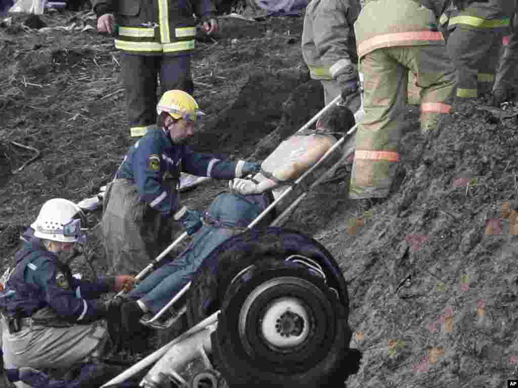 Rescue workers remove a body from the crash site.