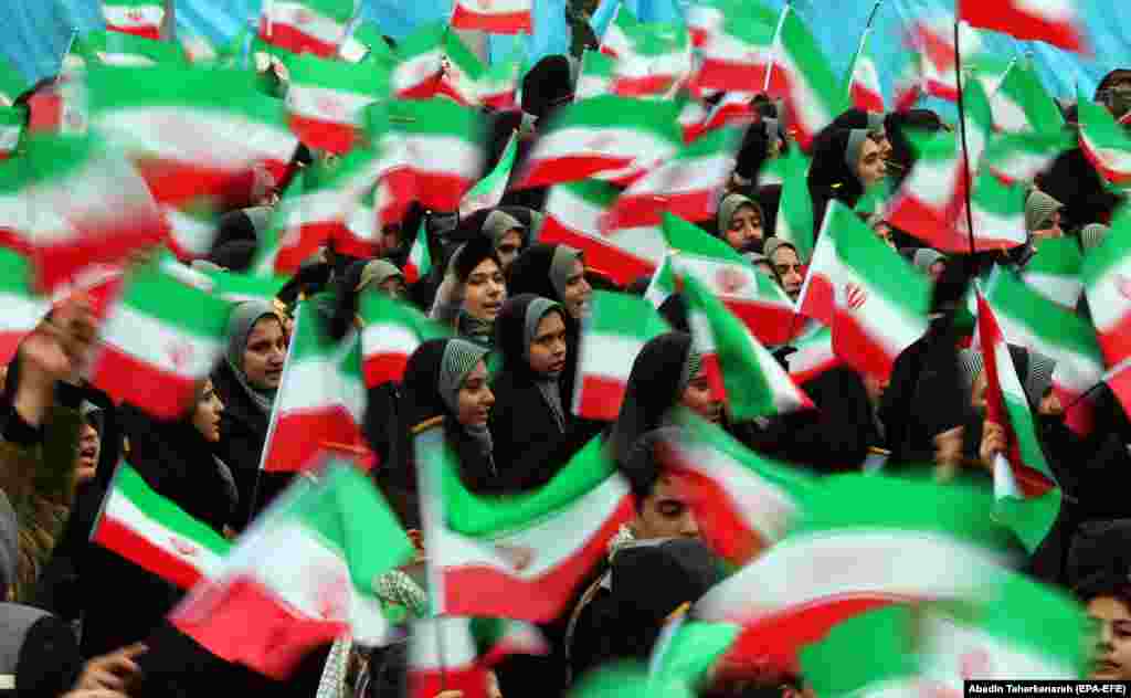 Female students wave national flags on Azadi (Freedom) Square.