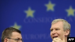 Belgium's caretaker prime minister, Yves Leterme (right), speaks with Foreign Minister Steven Vanackere during the presentation of the Belgian plan for the EU Presidency on June 25 in Brussels.