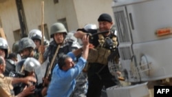 Iraqi police clash with exiled Iranian dissidents inside Camp Ashraf in 2009.