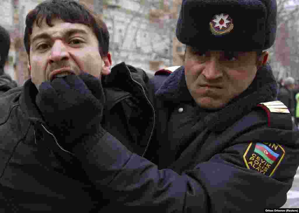 A policeman detains an opposition activist in Baku in 2011. Police crackdowns have muted dissent in the past, but with recent protests springing up spontaneously in small towns throughout the country the current unrest may be the harbinger of troubled times to come.&nbsp;