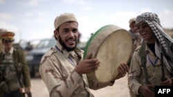 Libyan National Transitional Council fighters celebrate in the center of Bani Walid on October 17.