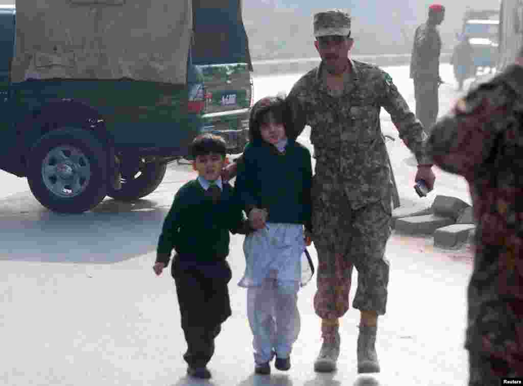 A soldier escorts schoolchildren after they were rescued from the Army Public School.